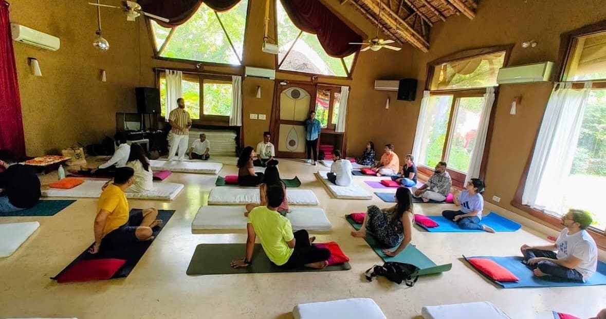 Participants on yoga mats journaling in a hall